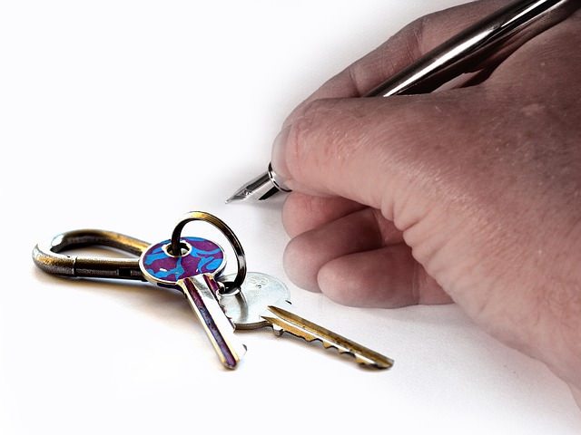 Mark Roemer image of a person getting ready to sign a rental agreement with keys on the table.